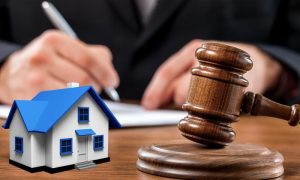 Wooden Gavel, model of house and partition attorney working in background