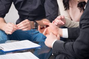 Hands of people signed the document, sitting at the desk