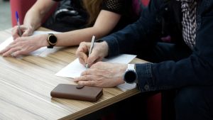 Adult man and woman fill out power of attorney forms.