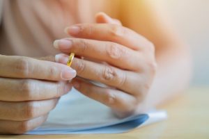 Woman taking off wedding ring and ready to sign divorce papers.