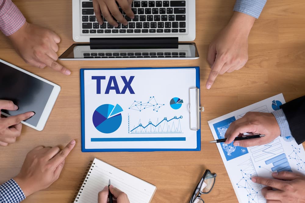 Tax Strategies for High-Net-Worth Individuals in Estate Planning Estate Planning team hands at work with tax reports on the laptop