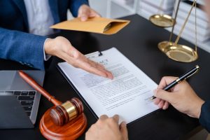 Legal counsel presenting a signed contract to client in office, symbolizing law and justice