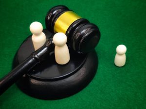Parental dolls with a child doll between them and a judge’s gavel in the background, symbolizing family court, custody, guardianship, and divorce.