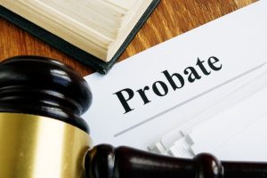 Probate sign displayed next to a stack of documents and a judge’s gavel on a wooden desk.