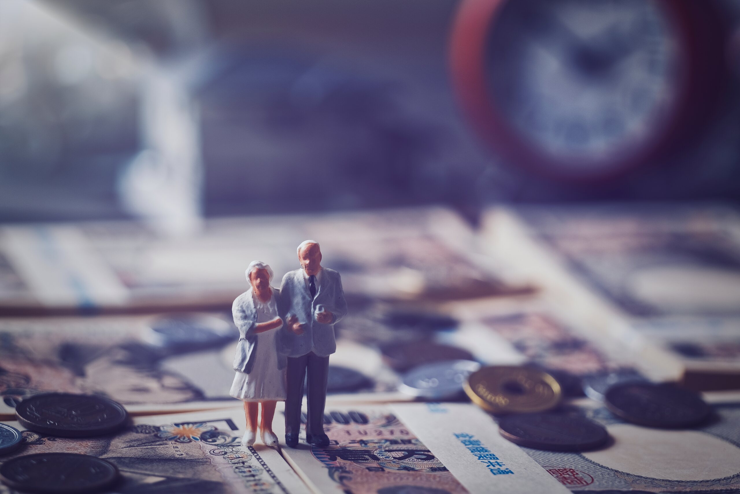 Miniature figures of an elderly couple on coins and cash, illustrating small estates in Florida that may qualify for summary administration.