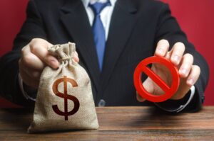 A person in a suit holding a money bag and a "no" sign, representing non-probate assets that transfer directly to beneficiaries in Florida.