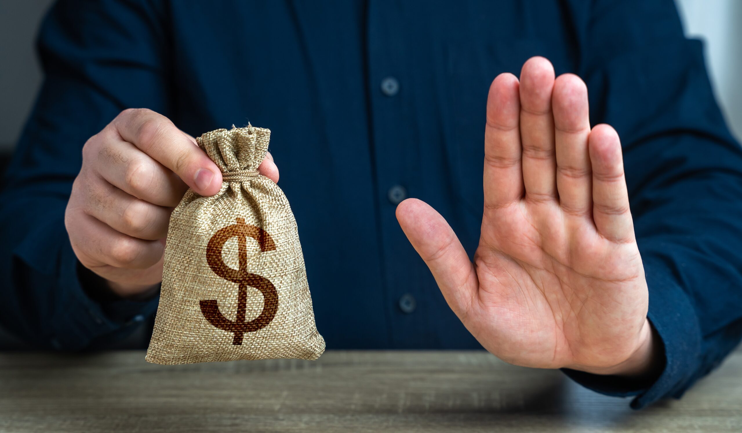 A man holding a money bag and gesturing stop to symbolize how a living trust or joint ownership helps assets avoid probate in Florida.