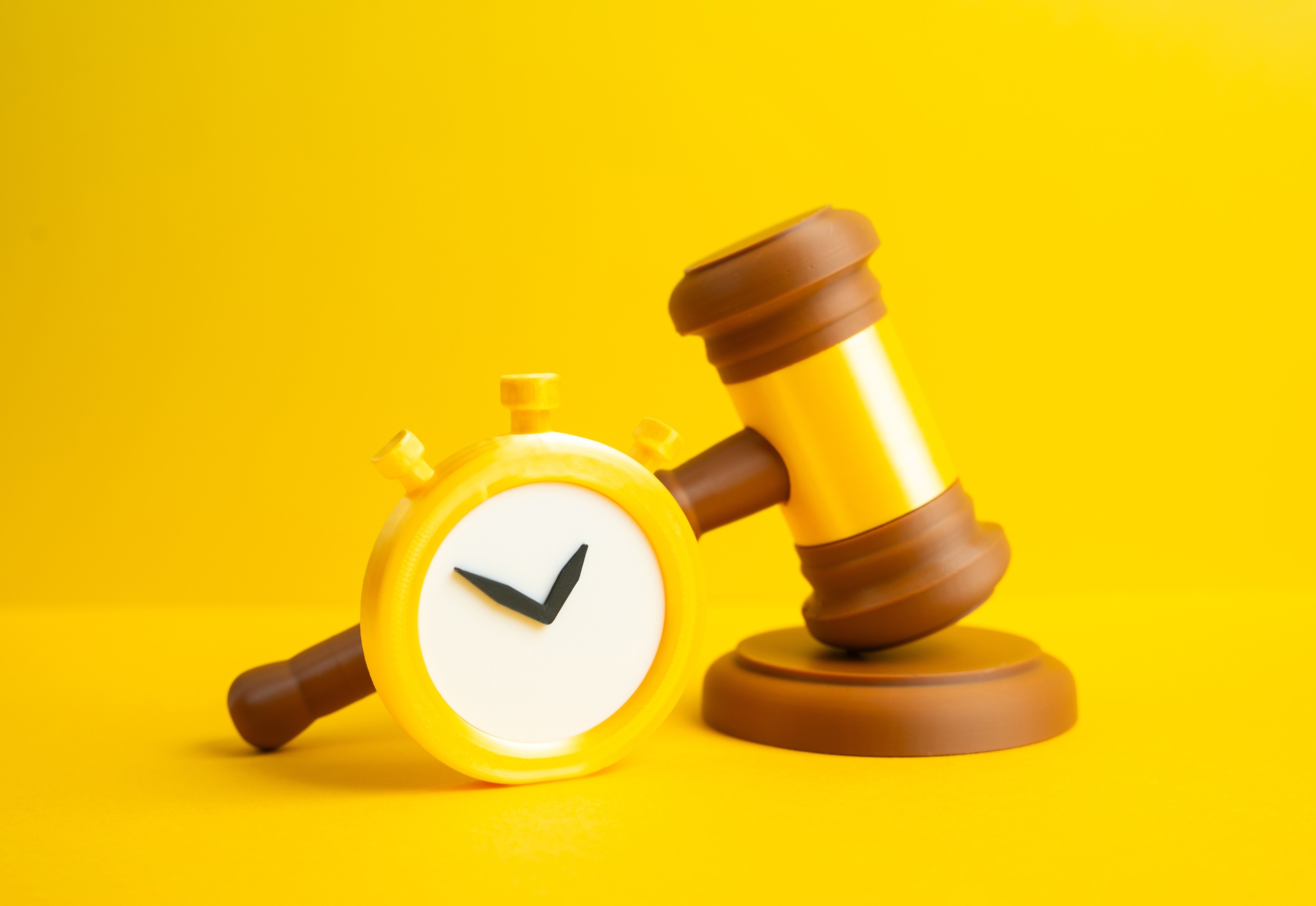 A wooden legal gavel next to a yellow clock symbol representing services provided by Coral Gables Probate Administration Attorneys.