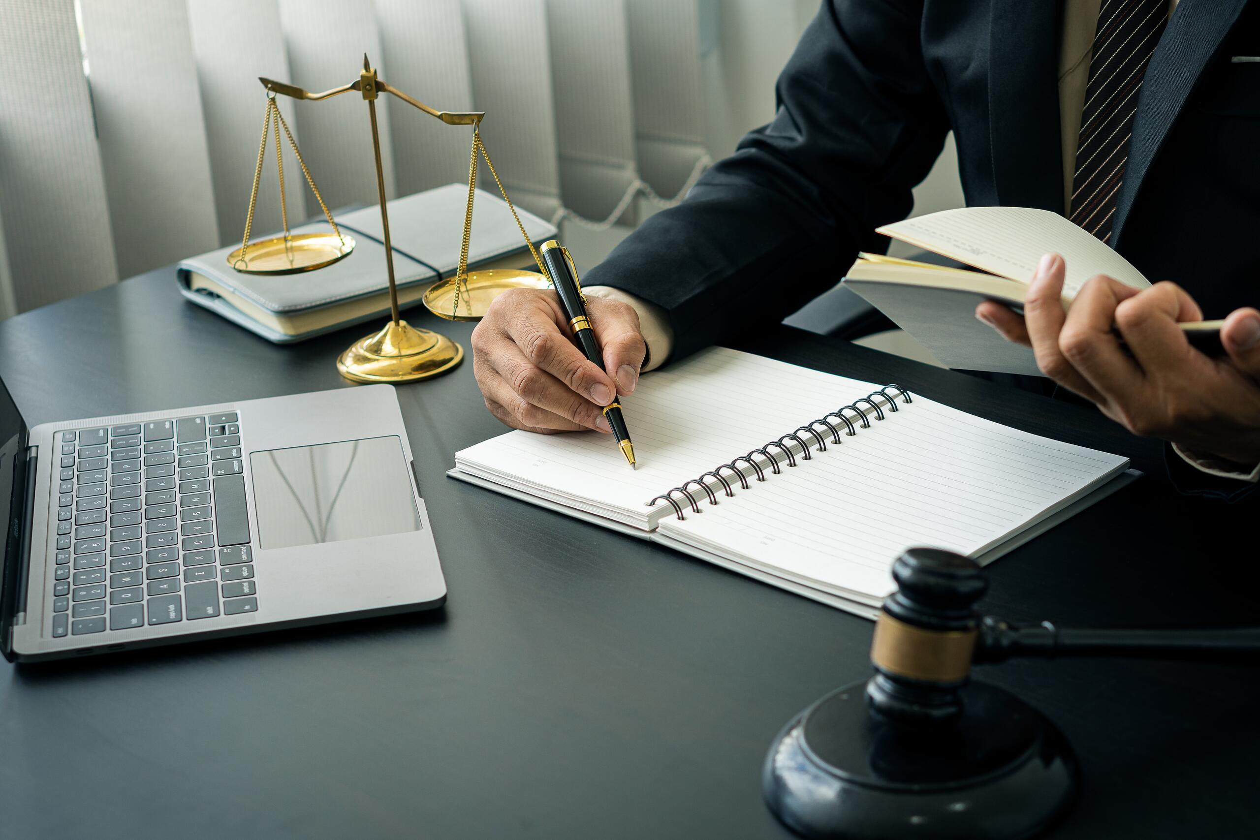 Lawyer reviewing estate notes at a desk with a scales of justice and gavel for Coral Gables probate attorneys.