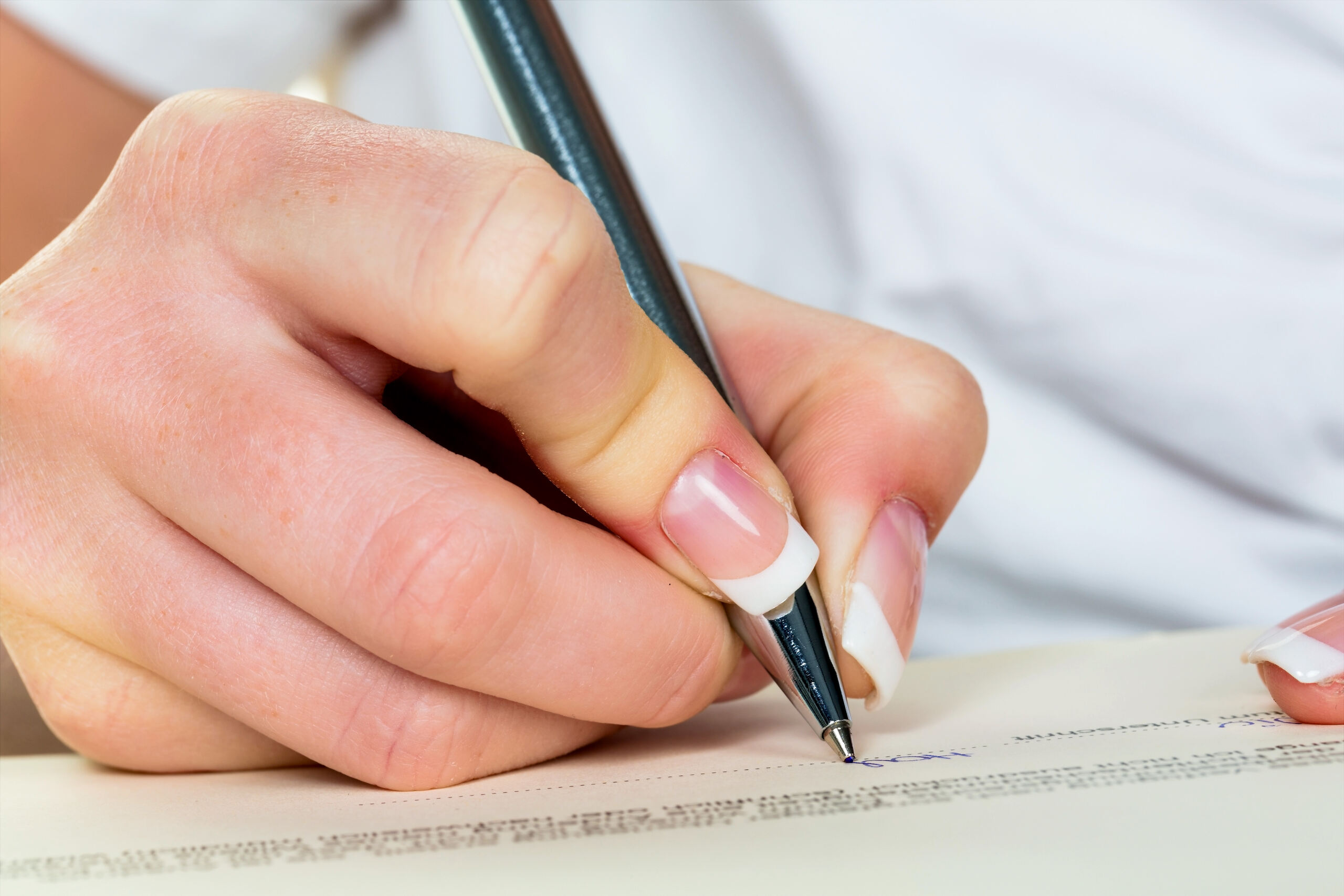 Close up of a hand signing estate planning forms showing living will vs. healthcare surrogate and why Coral Gables residents need both.